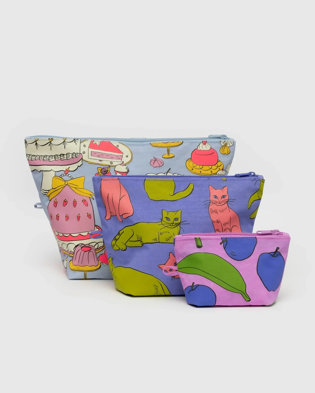 Three colorful Go Pouch Set bags with playful still life prints, perfect for organizing essentials with large, medium, and small sizes.