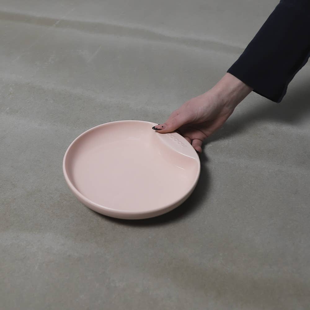 Person holding a shallow, wide, grey cat plate bowl made of high-quality porcelain, designed to prevent whisker fatigue.