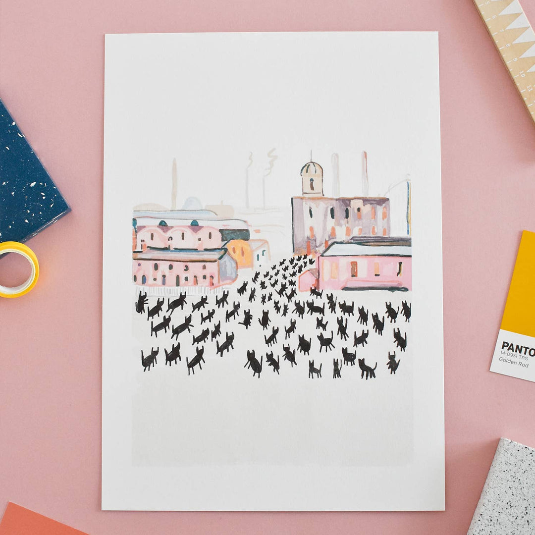 Art print depicting a whimsical city scene filled with playful black cats, inspired by L.S. Lowry's 'At Work'.