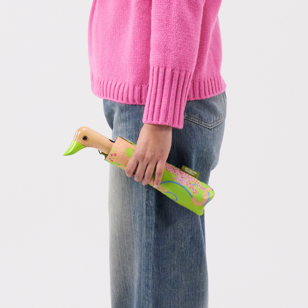 Duck Umbrella - Lime Arty Cats held by a person in pink sweater, showcasing its unique design.
