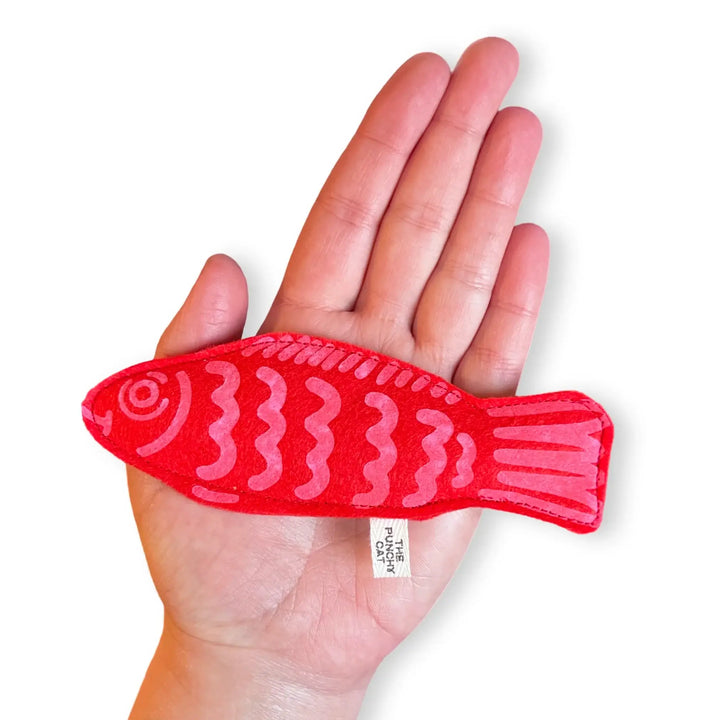 Handheld red candy fish cat toy made of wool felt, filled with catnip, showcasing unique handcrafted design.
