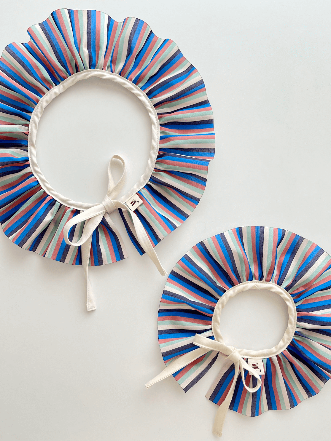 Saekdong cape for cats featuring thin stripes in vibrant colors, handmade in South Korea, perfect for stylish pets.