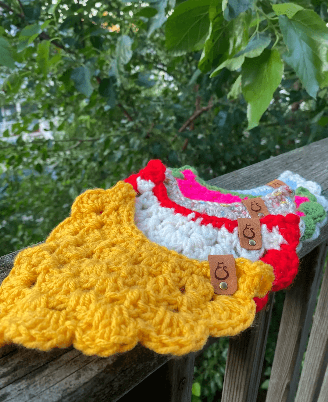 Colorful handmade cat bandanas crocheted with unique designs, perfect for attaching to cat collars.