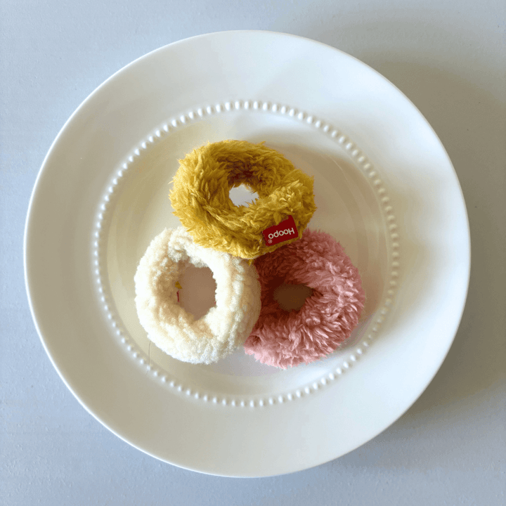 Set of 3 fluffy Mini Donuts cat toys in pink, white, and yellow on a white plate.