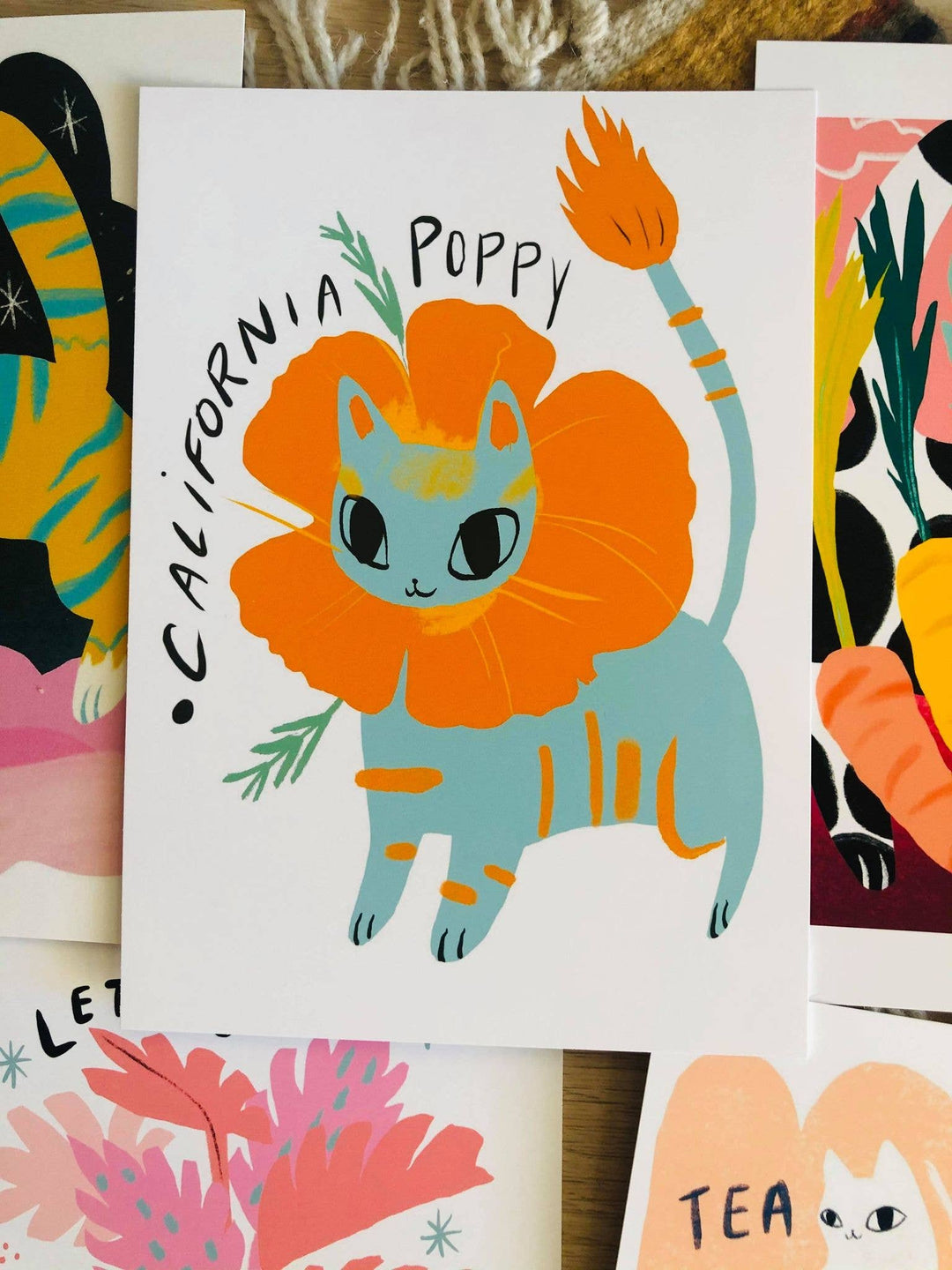 "California Poppy Cat Art Print in vibrant colors, featuring a blue cat with orange poppy flower, 5x7 fine matte paper print."