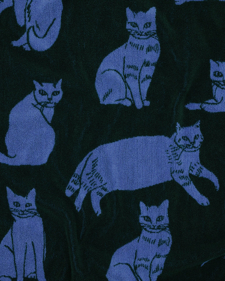 Close-up of Baggu Bath Towel in blue and dark green, featuring cat illustrations, made from soft, organic cotton terrycloth.