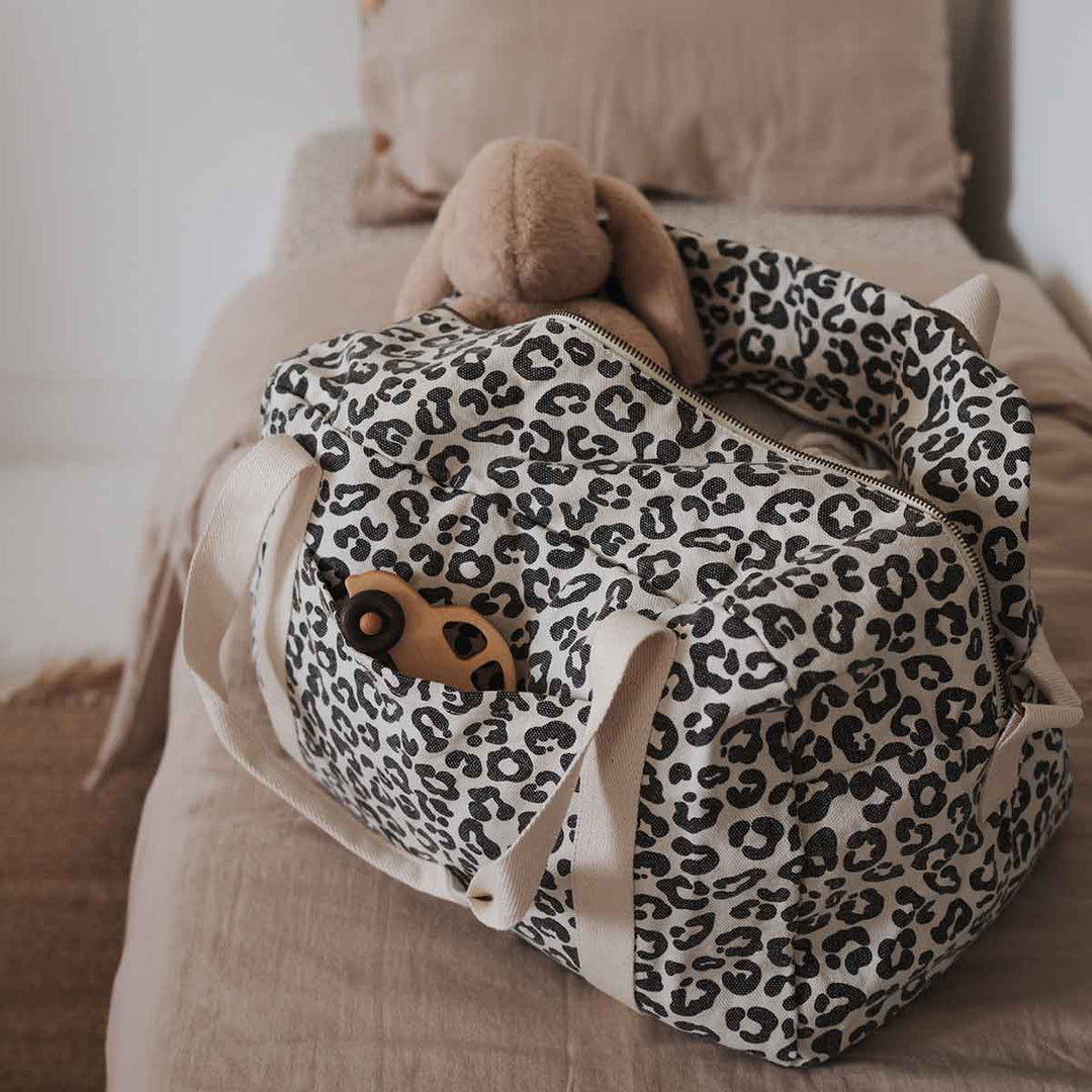 Stylish leopard print bowling bag, perfect as a diaper, sports, or tote bag, featuring exterior pockets and a waterproof interior.