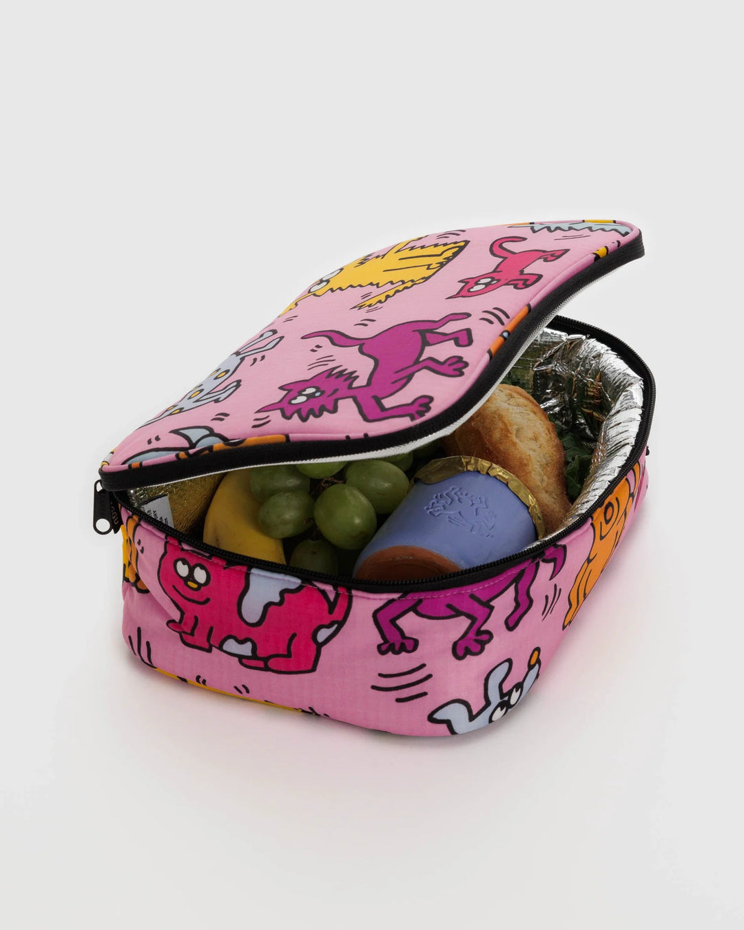 Insulated Keith Haring Pets lunch box filled with a sandwich, grapes, and a drink with pink exterior featuring playful pet illustrations