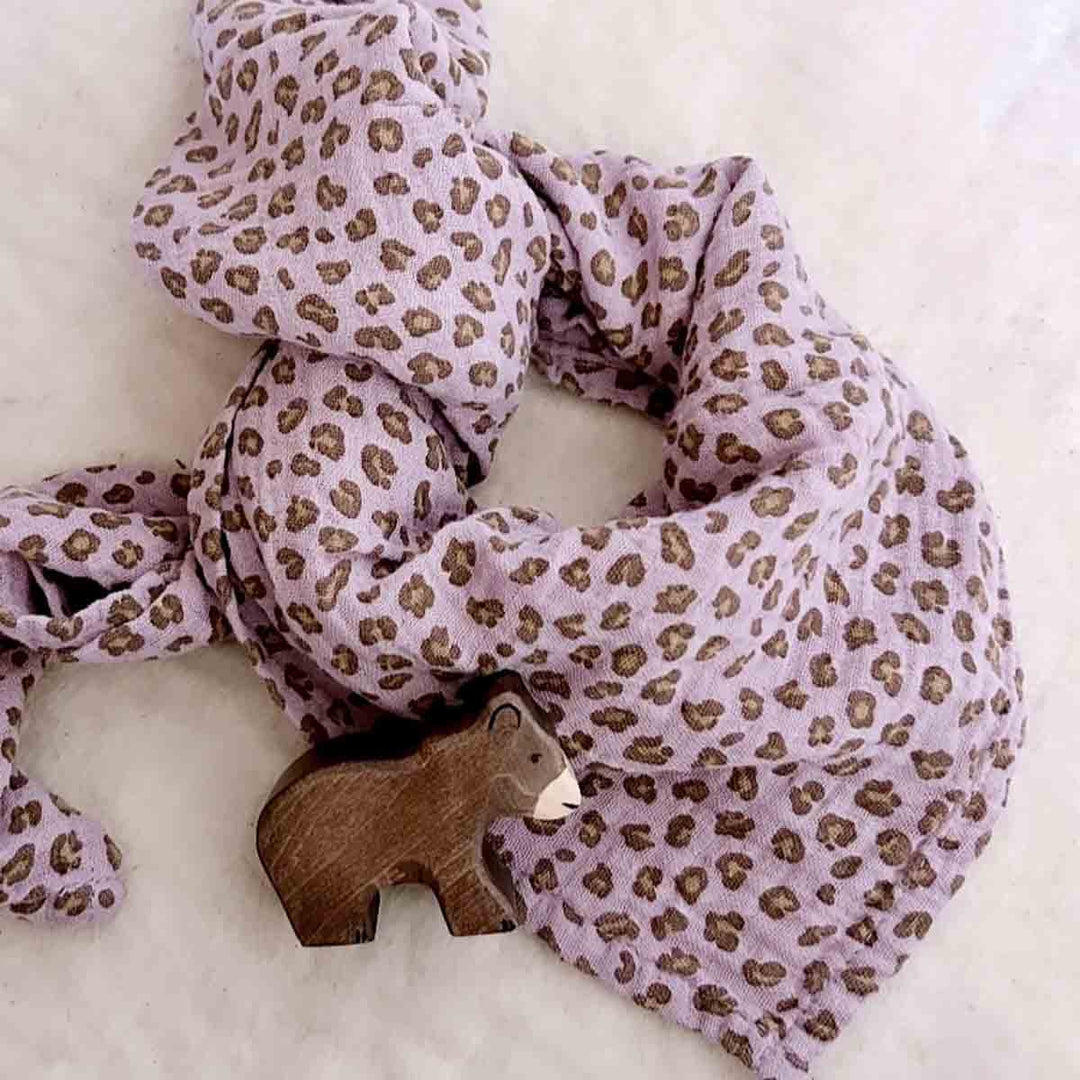 Bianca Swaddle in lilac leopard print with wooden bear toy, versatile baby blanket, 100% cotton muslin.
