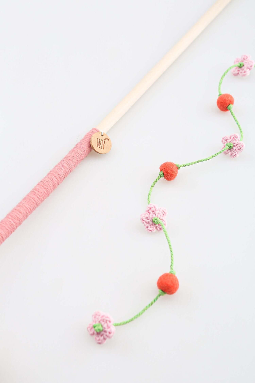 Luxury cat toy featuring a cherry blossom wand with pink and orange accents, handmade from quality materials.