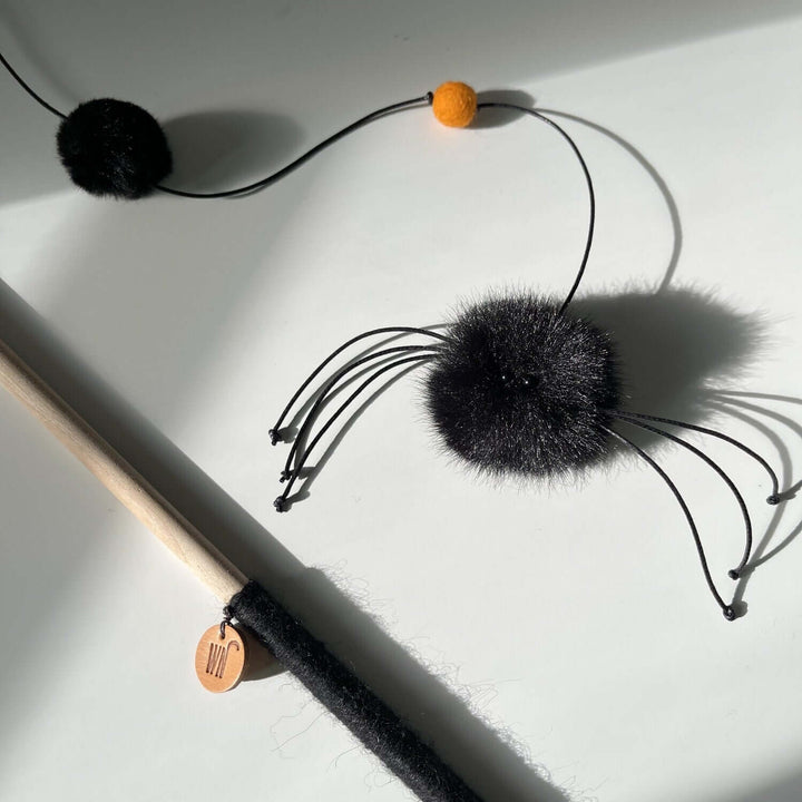 Tarantula wand toy with fluffy black spider design for cats, featuring a 50cm string and orange pom-pom, handmade in South Korea.